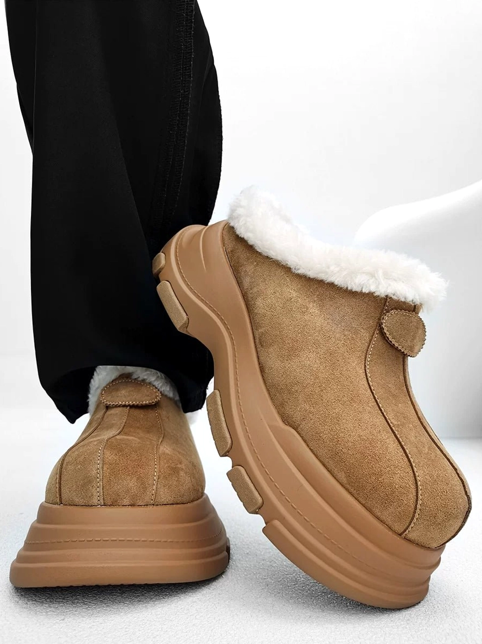 Tan suede-finish fleece-lined platform clogs shown from a low rear side angle with fluffy faux-fur collar, chunky winter outsole, and decorative heel strap