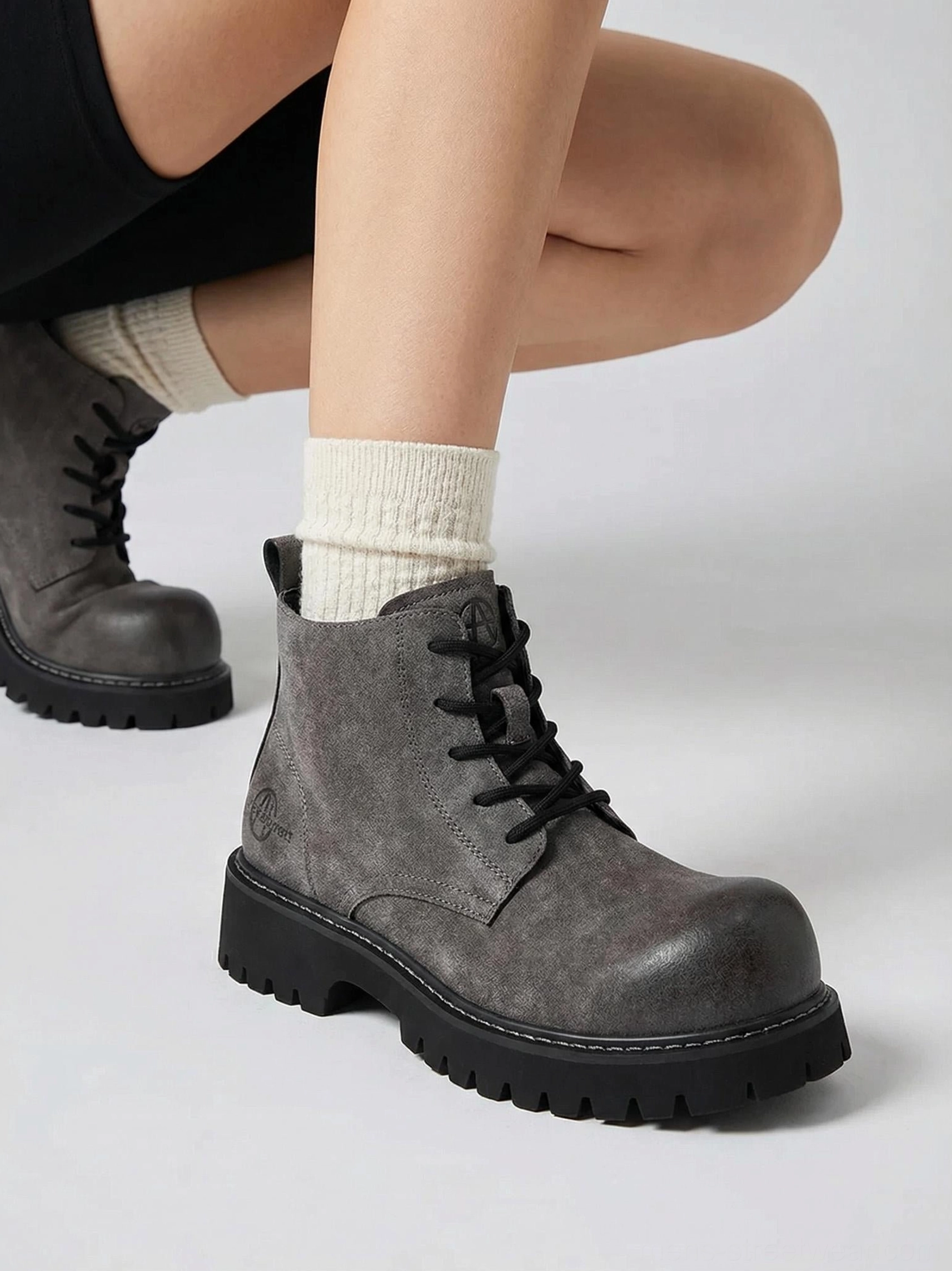 Tan utility boots with deep lug tread, lace-up closure, and weathered finish for gorpcore outfits