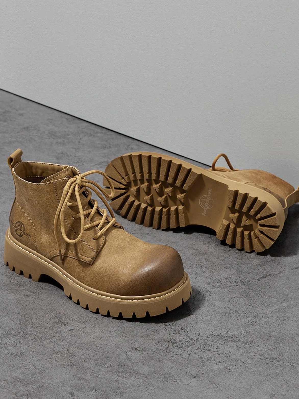 Tan workwear-inspired lug boots with round toe and muted neutral finish for everyday styling