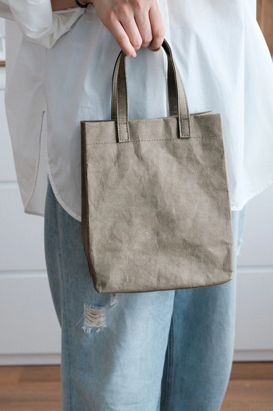Neutral taupe gray crinkled kraft paper texture cotton tote bag worn with white shirt and distressed denim