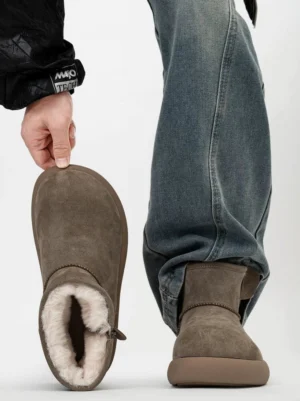 Taupe suede shearling ankle boots shown from the top and side on a male model wearing blue jeans, featuring warm fleece lining, a chunky platform sole, and a rear pull tab
