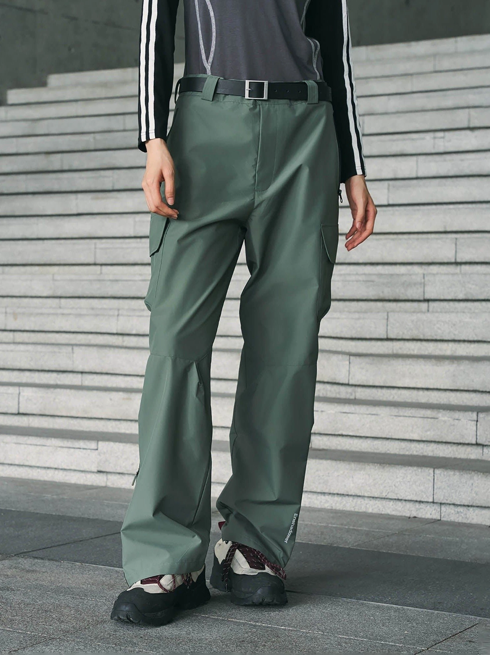 Sage green techwear waterproof cargo pants shown in a full front view with a relaxed straight-leg fit and outdoor hiking shoes