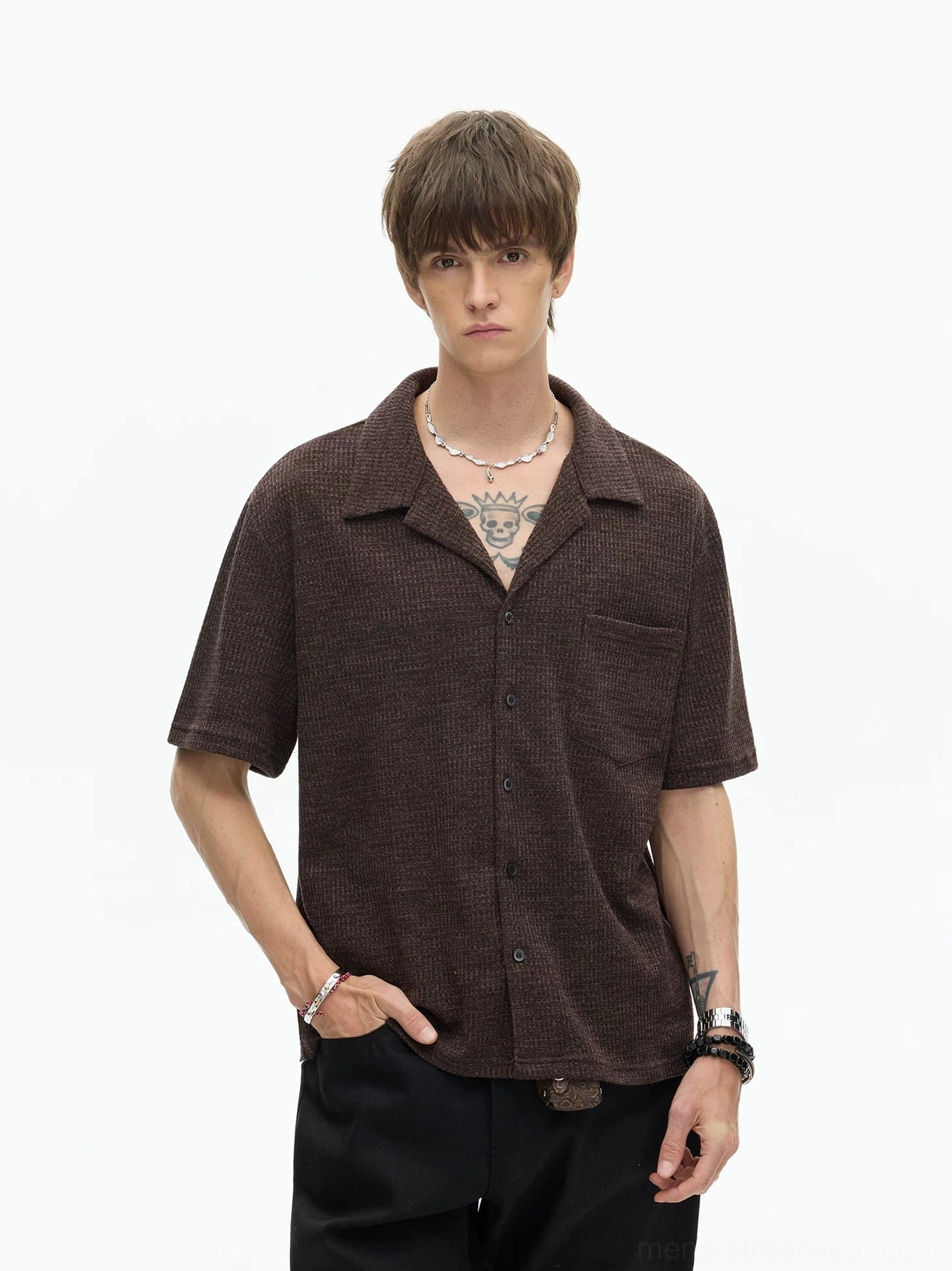 Brown textured camp collar shirt with short sleeves, relaxed boxy fit, front buttons, and chest patch pocket styled with black loose trousers