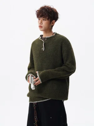 Dark olive green textured henley sweater with contrast stitching and button placket styled with loose black pants