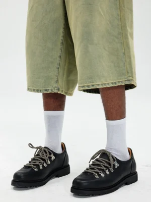 Black textured suede metal-eyelet derby shoes styled with cropped light green jeans and white crew socks