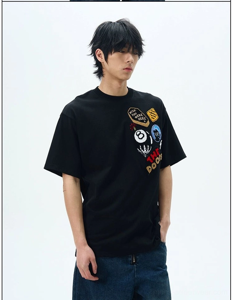 Black THE DOODS graffiti graphic patch oversized streetwear T-shirt styled with dark blue wide-leg denim