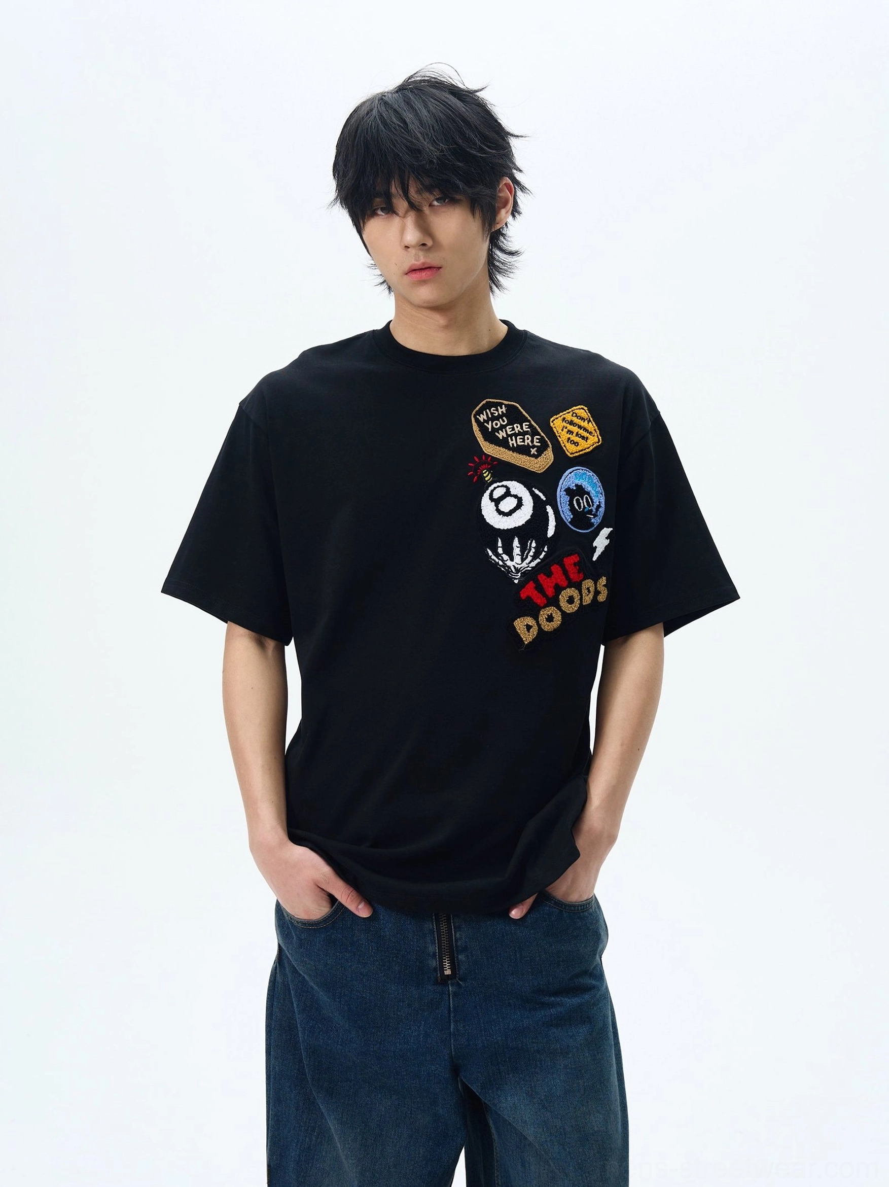 Black THE DOODS graphic patch oversized streetwear T-shirt styled with dark blue wide-leg jeans