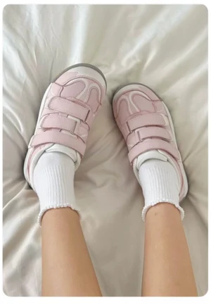 Worn pink triple strap casual sneakers shown from above with white crew socks and adjustable hook-and-loop straps