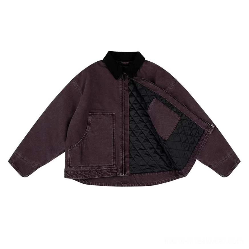 Two-tone burgundy cotton canvas work jacket shown from the front at an angle with black corduroy collar, chest patch pocket, metal zipper, and diamond quilted lining