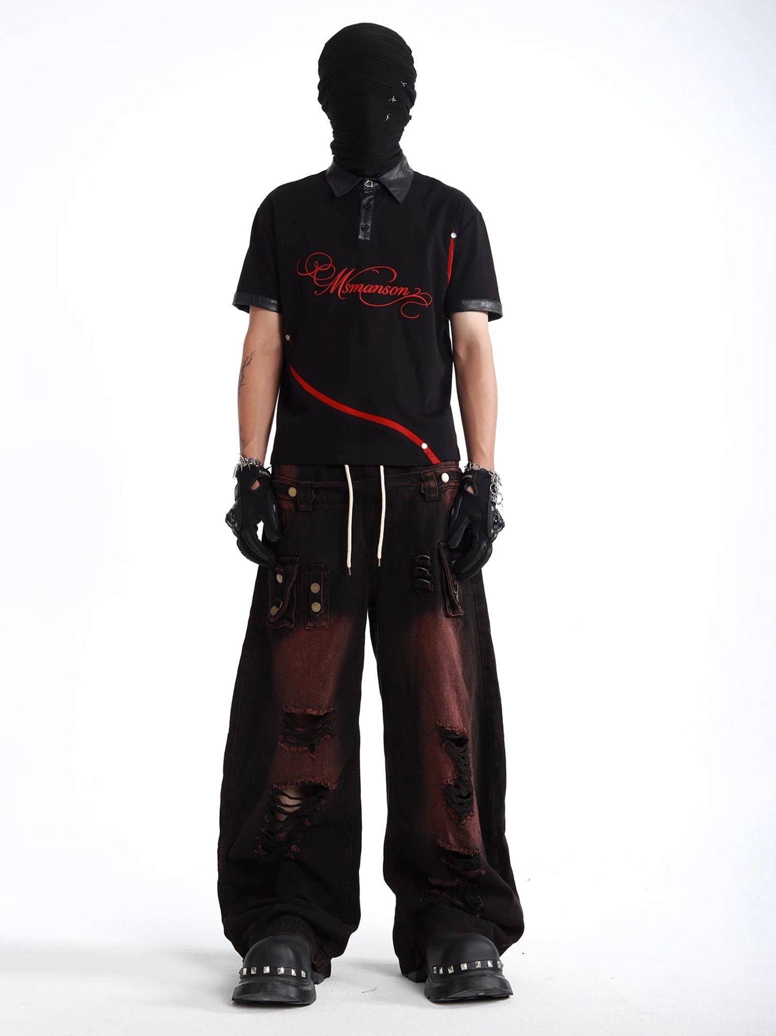 Full-body streetwear outfit featuring two-tone distressed wide-leg cargo denim pants graphic polo shirt and studded accessories