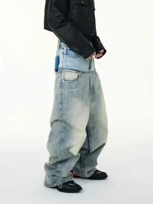 Left side view of two tone washed blue high waisted baggy jeans showing the layered waistband pocket detail and wide relaxed leg