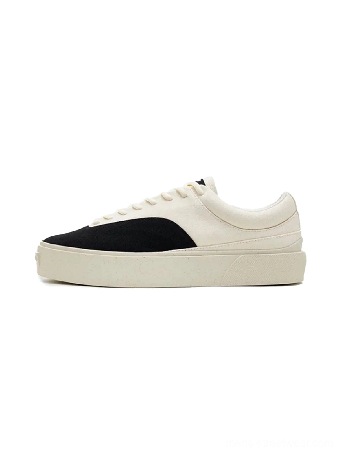 Side view of two-tone off-white and black platform canvas skate shoes with lace-up low-top silhouette and thick speckled rubber outsole