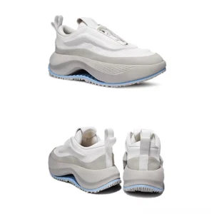 Front three-quarter view of two-tone off-white and light gray Korean streetwear sneakers with dual pull tabs, curved chunky midsole, and light blue outsole trim