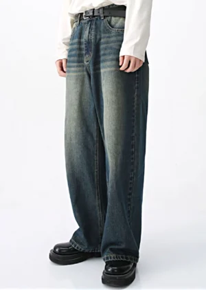 Front three-quarter view of mid-blue vintage wash wide-leg jeans showing darker contrast side panels, loose denim leg shape, and classic waistband