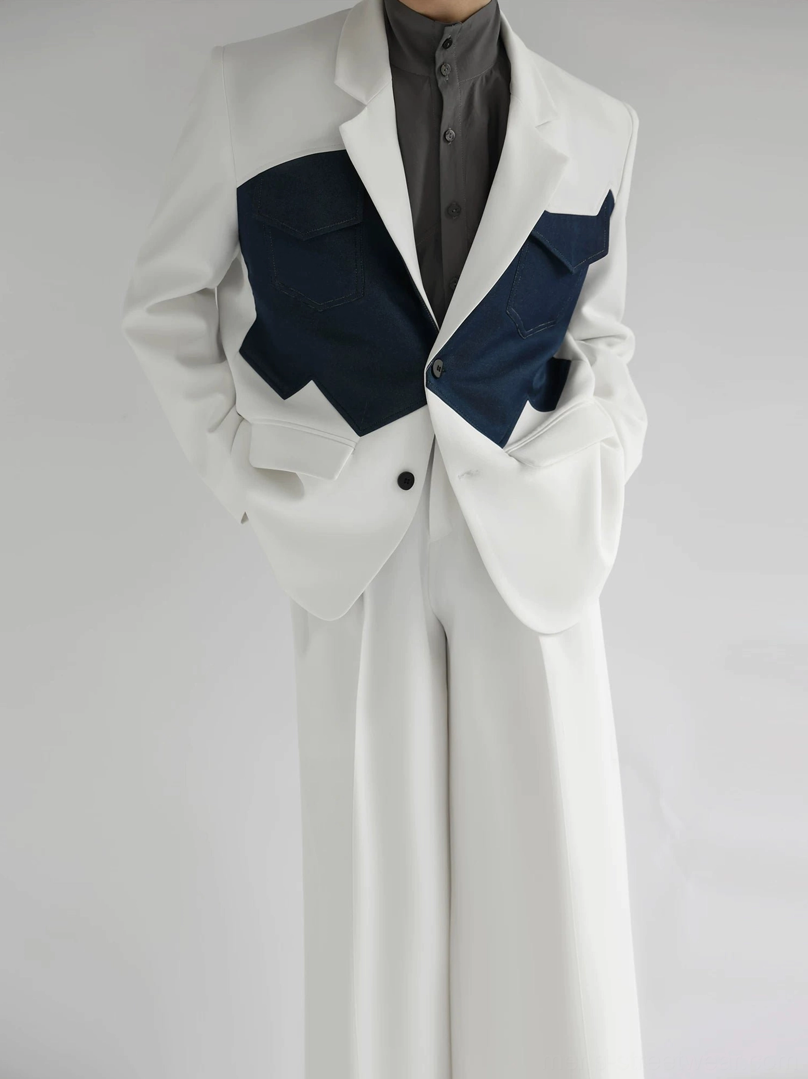 Front view of a two-tone ivory and navy Western color-block blazer with jagged denim-style chest pockets and matching wide-leg trousers