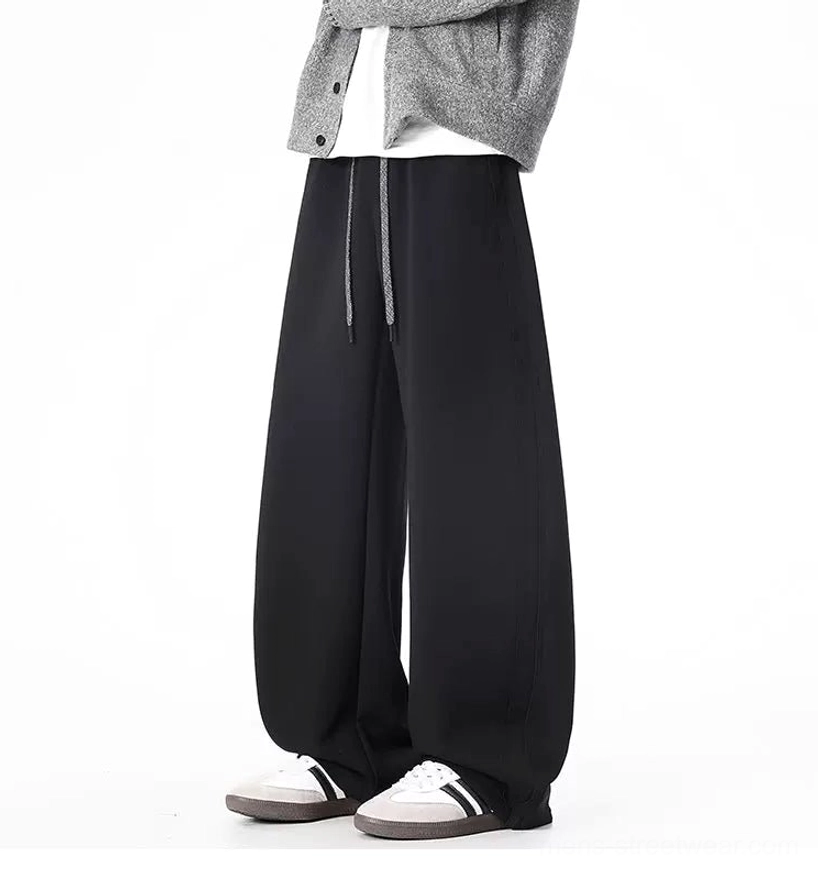 Black wide-leg sweatpants close view with adjustable drawstring waistband and smooth knit finish