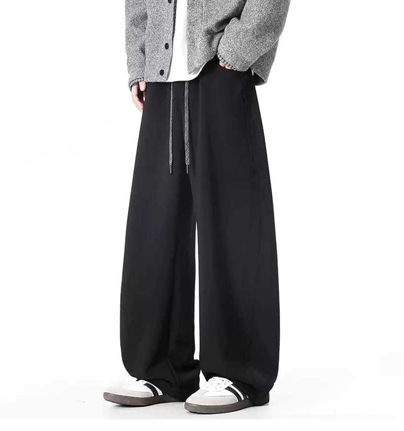 Black ultra-wide drawstring sweatpants front view styled with sneakers for Korean streetwear