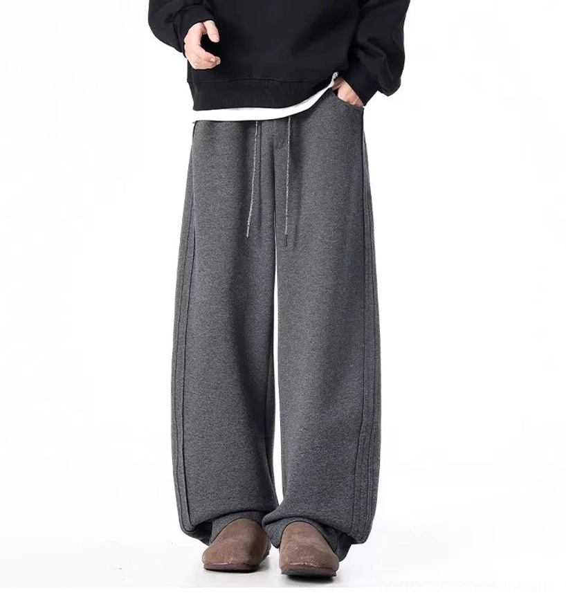 Dark gray baggy wide-leg sweatpants with hands in pockets styled for Korean streetwear