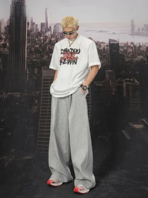 Front view of light grey ultra wide sweatpants styled with a graphic T-shirt in a modern Seoul streetwear outfit