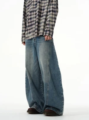 Side view of oversized blue balloon jeans showing the relaxed wide-leg shape and vertical side seam details