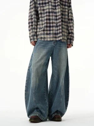 Front full-body view of vintage washed blue ultra wide-leg balloon jeans styled with a plaid shirt in a clean streetwear studio outfit