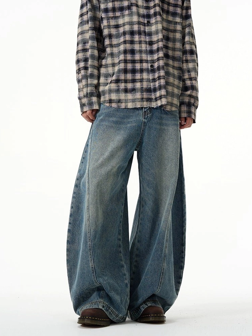 Front full-body view of vintage washed blue ultra wide-leg balloon jeans styled with a plaid shirt in a clean streetwear studio outfit