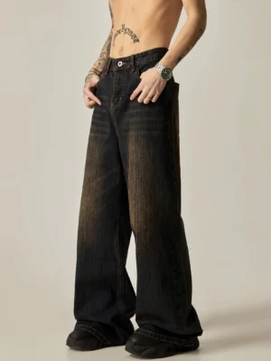 Front three-quarter view of ultra-wide leg faded denim jeans with contrast stitching, relaxed fit, and chunky black sneaker styling