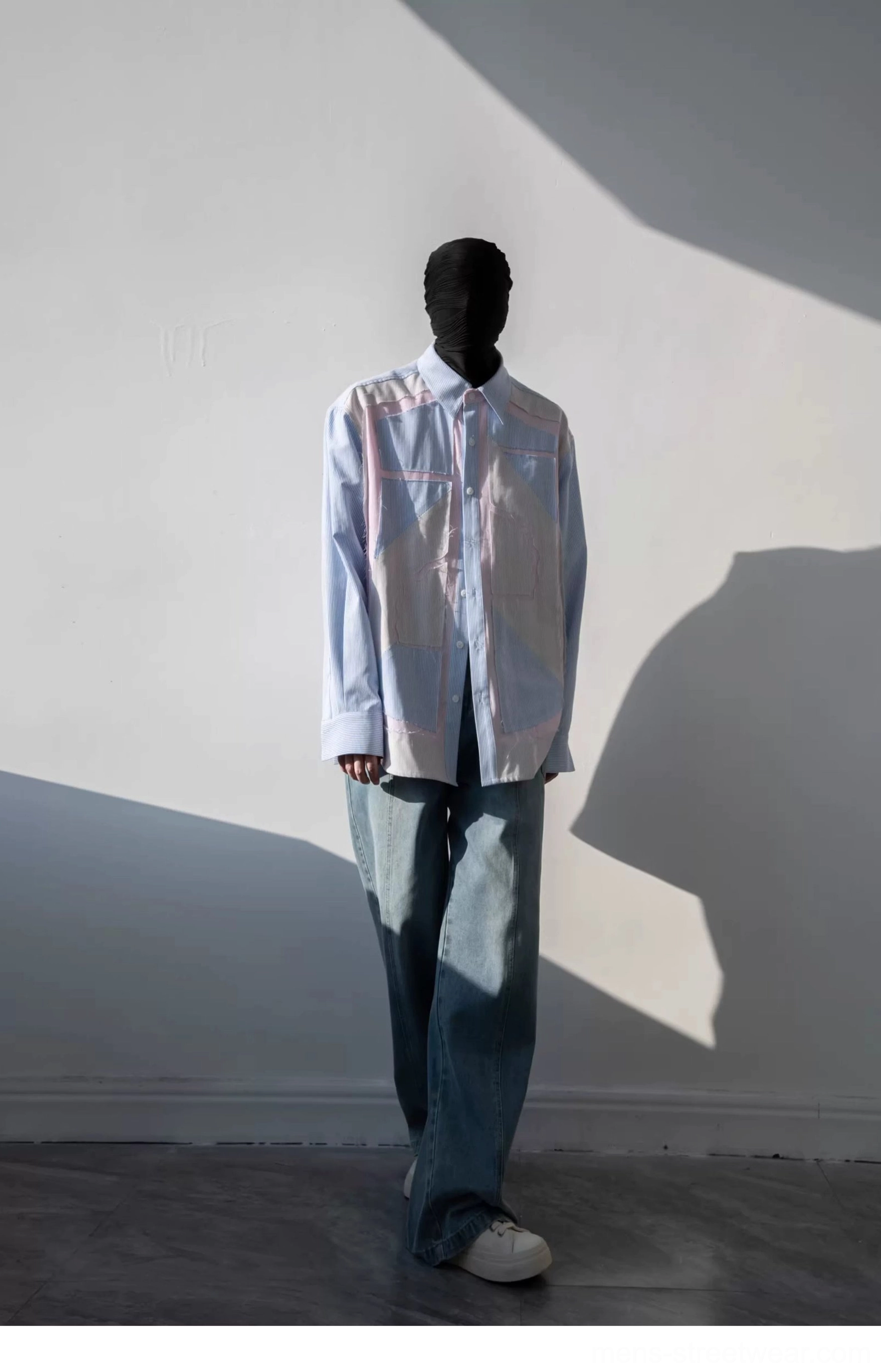 Unbuttoned light blue geometric patchwork pinstripe shirt layered over a white tee with relaxed denim