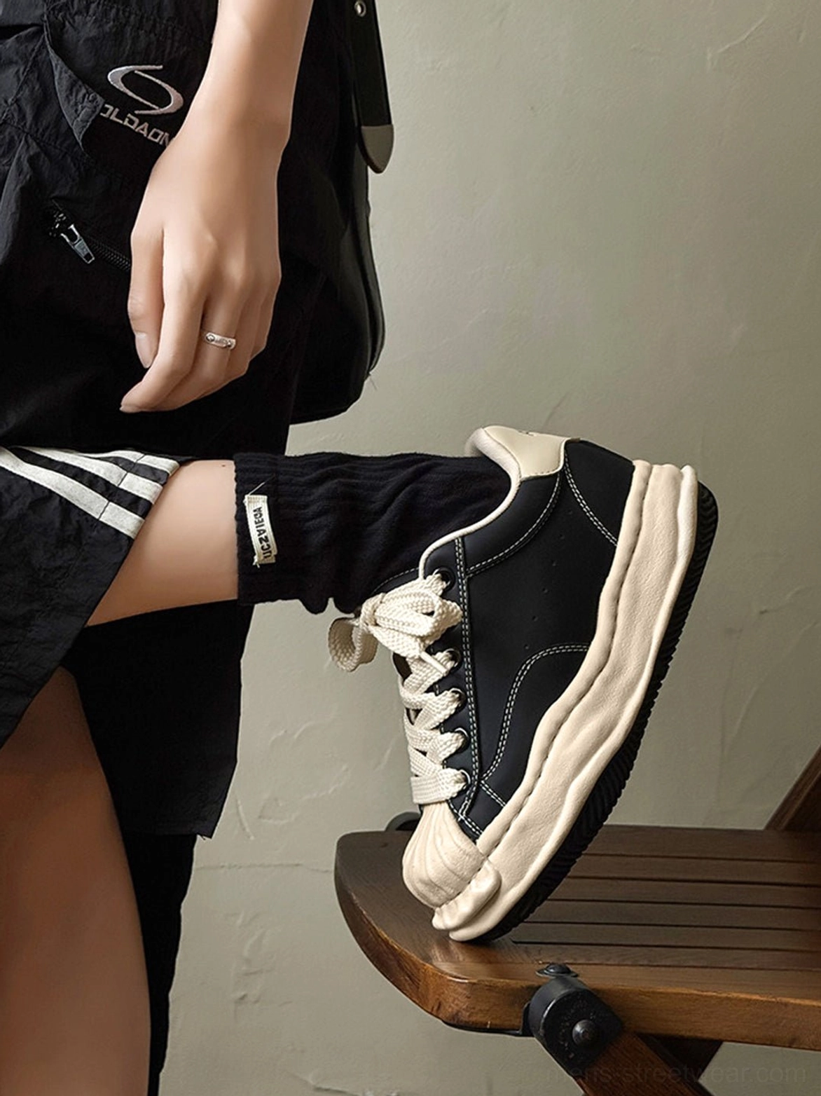 Unisex black shell-toe platform sneakers showcasing the sculpted elevated outsole and distressed finish