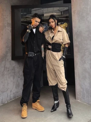 Front view of matching unisex cargo workwear jumpsuits with short sleeves utility belts and pointed boots