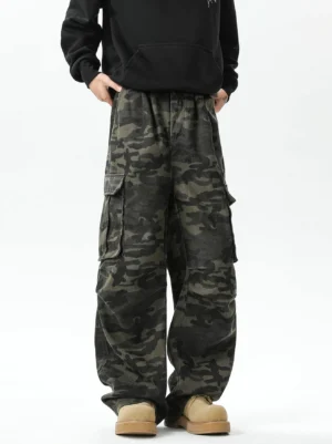 Full front studio view of dark green camouflage wide-leg cargo pants with elastic waistband, loose streetwear fit, and work boots