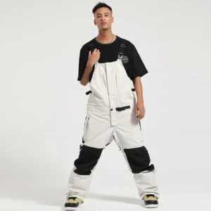 Unisex colorblock bib snow pants with white shell, black reinforced knee panels, adjustable suspenders, and oversized wide-leg snowboard fit