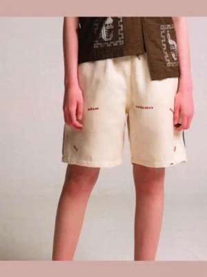 Apricot urban text graphic relaxed shorts with subtle front lettering and Korean streetwear styling