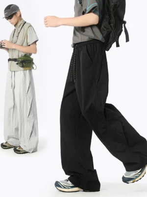 Black and gray vent mesh wide leg balloon pants shown in side profile on male streetwear models