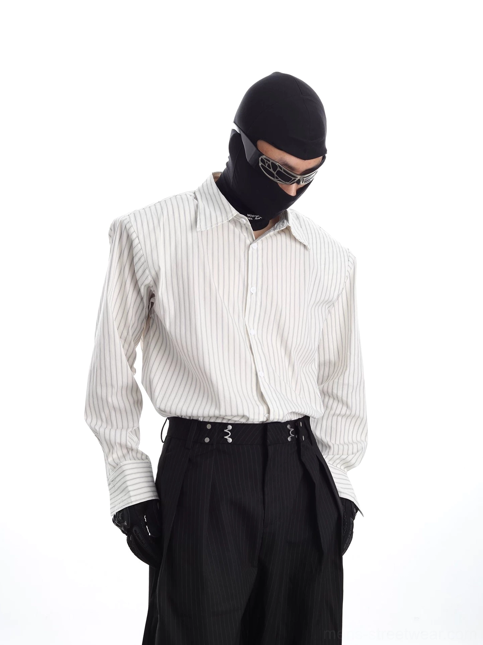 Front full-body view of a relaxed vertical stripe Oxford shirt styled with black wide-leg trousers and tactical streetwear accessories
