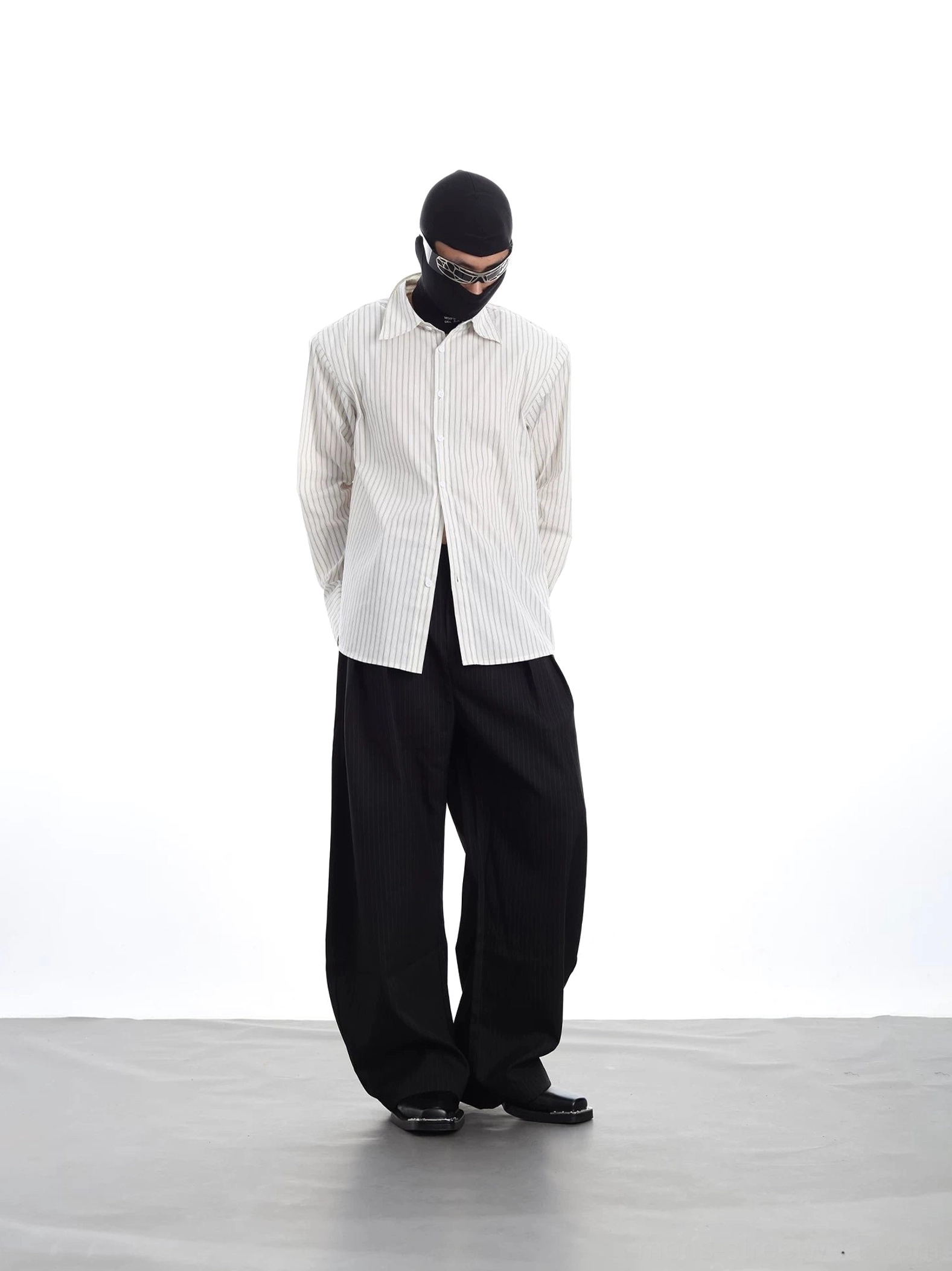 Low-angle side view of a vertical stripe Oxford shirt styled with black high-waisted wide-leg pants in modern Korean fashion