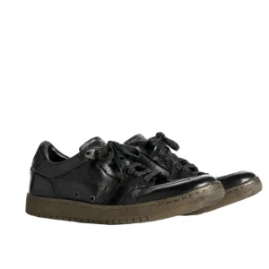 Paired vintage black horsehide leather low-top sneakers with distressed finish, lace-up streetwear design, layered panels, and dark brown rubber outsole