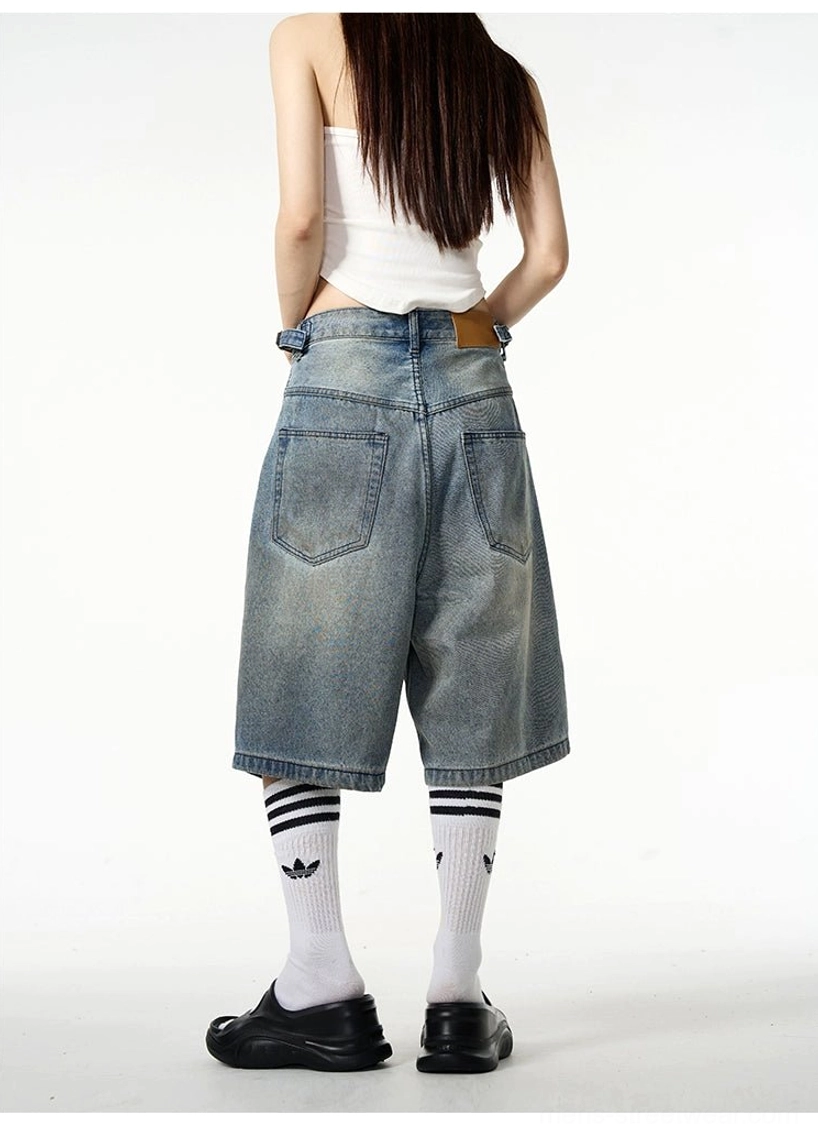 Back view of vintage blue denim Bermuda shorts showing the classic rear pocket design, relaxed wide-leg fit, striped socks, and black loafers
