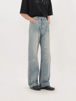Front view of relaxed vintage blue wide-leg denim jeans with washed fading, distressed thighs, and roomy streetwear fit