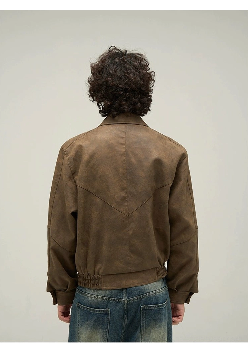 Back close-up of a vintage brown faux leather jacket showing stitched back yoke, ribbed hem, and weathered streetwear finish