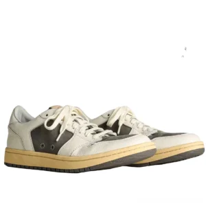 Vintage color-block cowhide leather court sneakers in off-white and charcoal grey with aged rubber soles front three-quarter view