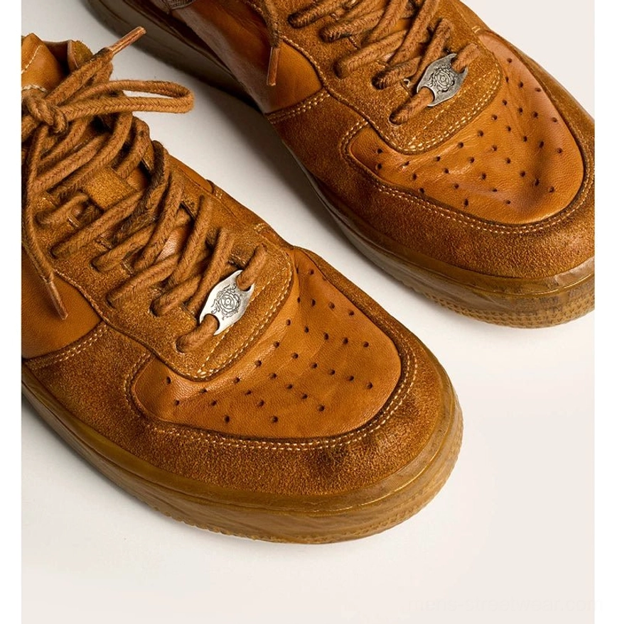 Rear three-quarter view of vintage distressed brown leather sneakers with smooth heel panels and worn rubber soles