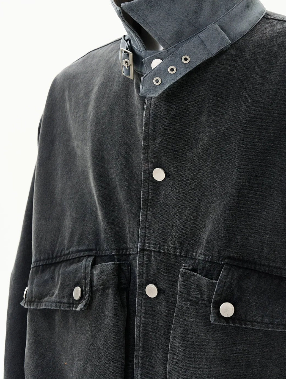 Close-up of dark grey duck canvas work jacket showing snap buttons flap pockets and adjustable collar tab