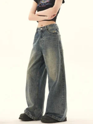 Three-quarter side view of faded vintage wide-leg jeans showing the relaxed silhouette high-rise waist and classic denim hardware