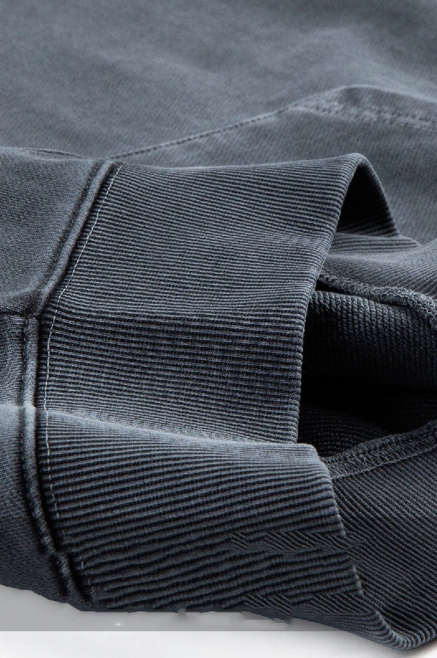 Close-up detail of faded washed cotton hoodie fabric ribbed cuff hem and reinforced seam stitching