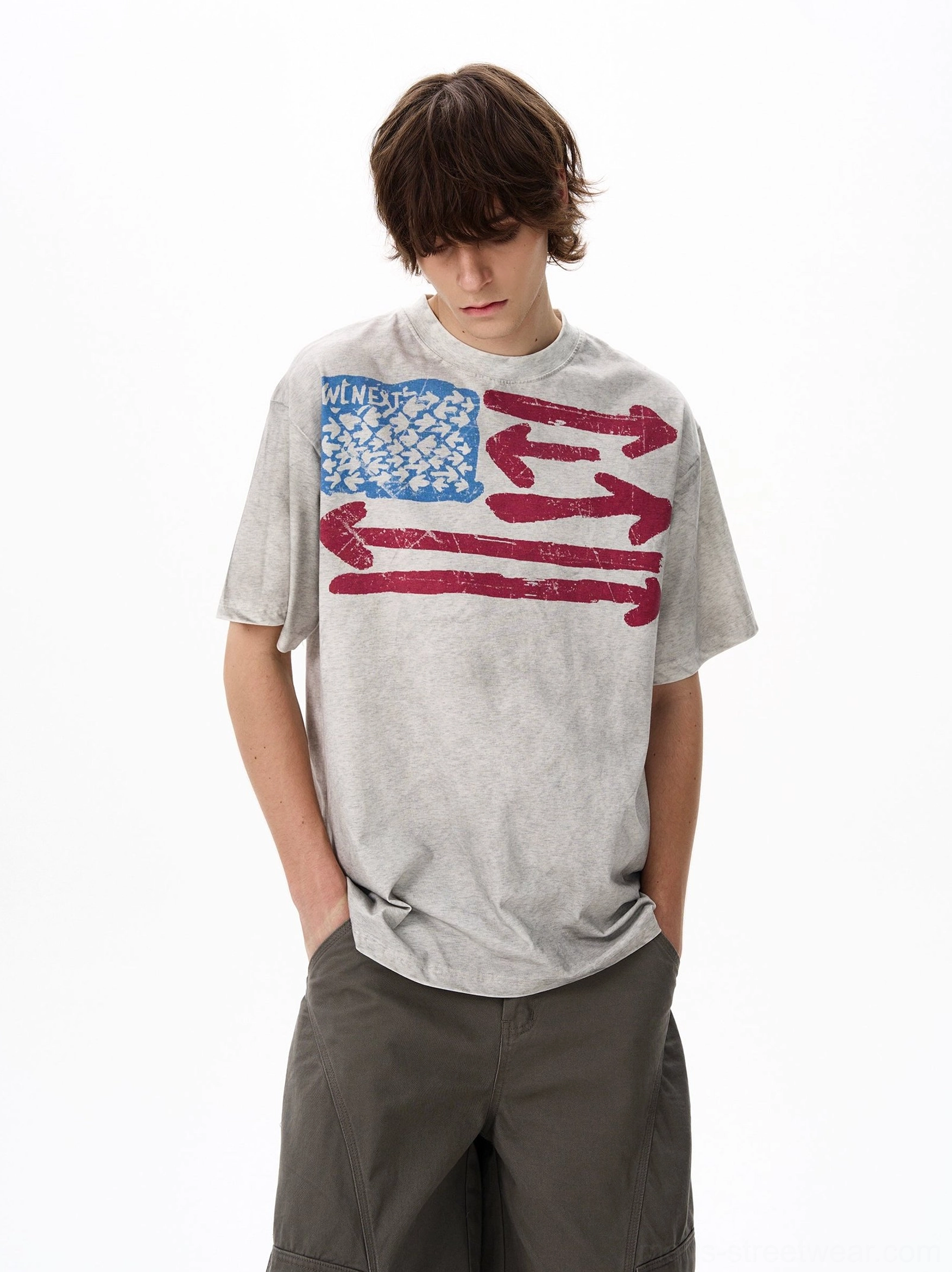 Front close-up of a vintage flag graphic oversized T-shirt in acid-washed light gray heavyweight cotton with distressed retro chest print