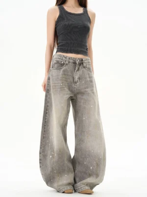 Vintage gray paint splatter ultra wide leg jeans front view worn with a gray tank top in a white studio