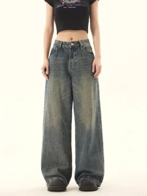 Front full-body view of vintage high-rise wide-leg blue jeans with a faded distressed wash styled with a black cropped tee