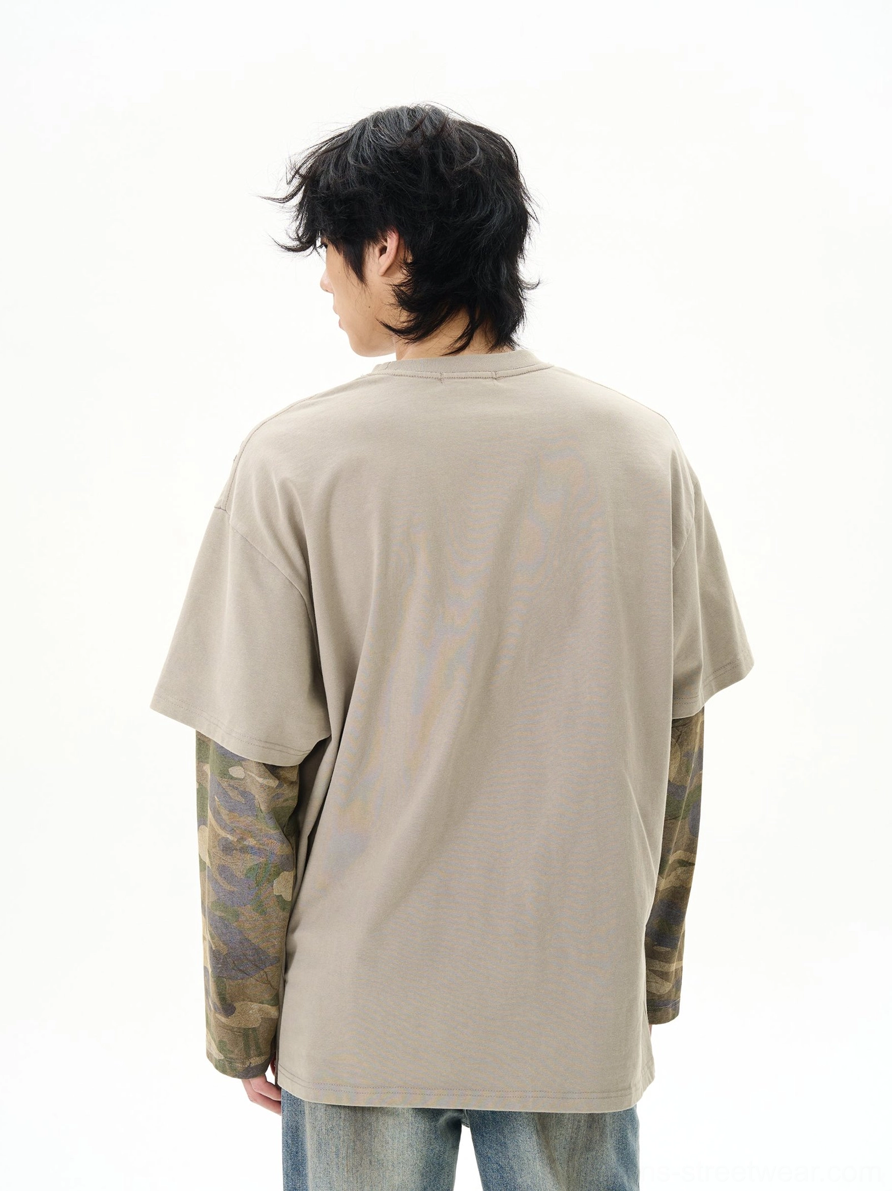 Back view of dusty khaki oversized layered t-shirt showing plain back panel and camouflage long undersleeves