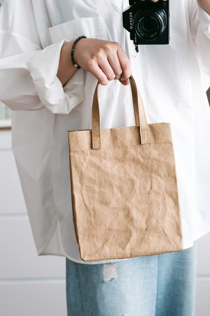 Light khaki crinkled kraft paper texture cotton tote bag worn with white shirt and ripped blue jeans